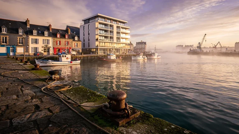 Vue hyperréaliste du port de Brest au coucher de soleil, symbolisant la recherche immobilière et biens perdus